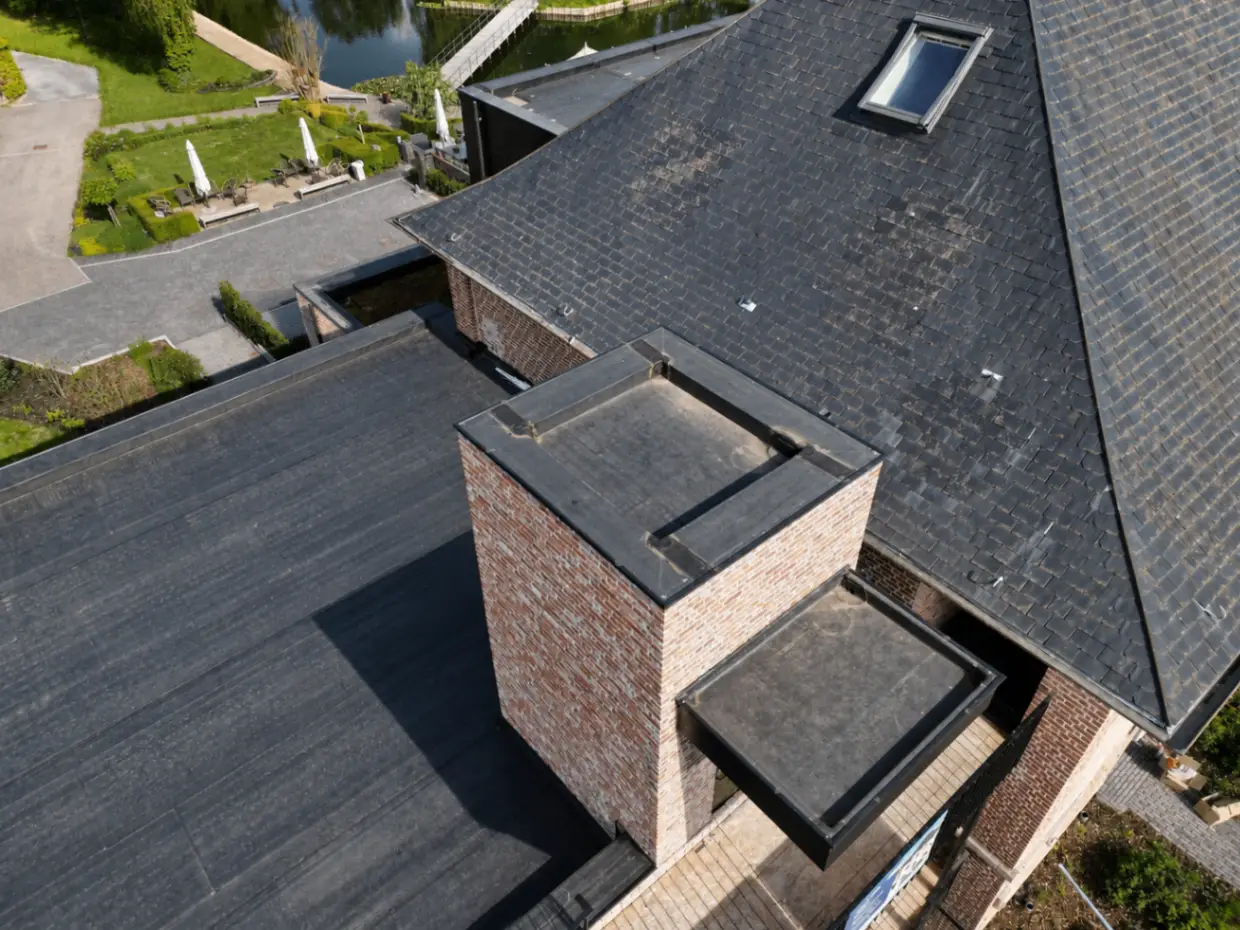Aerial detail van schouw, leien dak en platte daken op De Castel