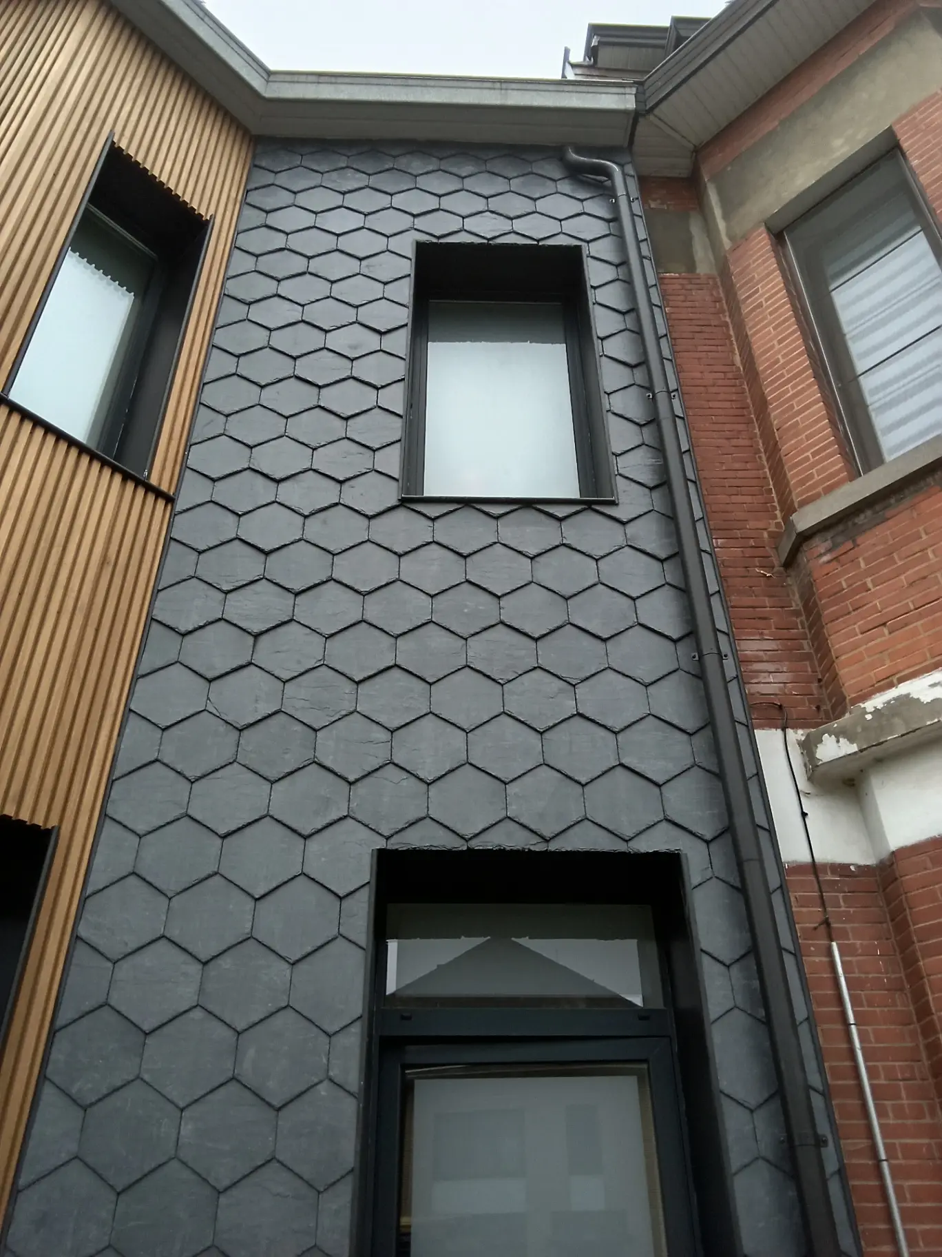 Uitvoering van Honeycomb natuurleien, warm hout en maatwerk zink
